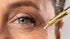 Gotero de skin care con retinal aplicando el producto sobre las arrugas cerca al ojo